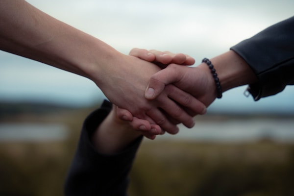 Two people shake hands, possibly a deal